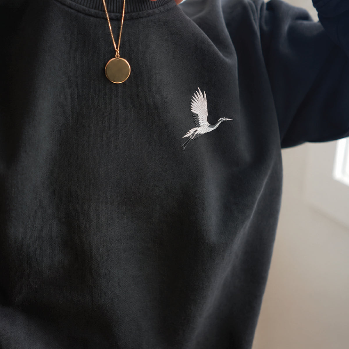 Origami Echo Crewneck in Black, crane embroidery at the chest