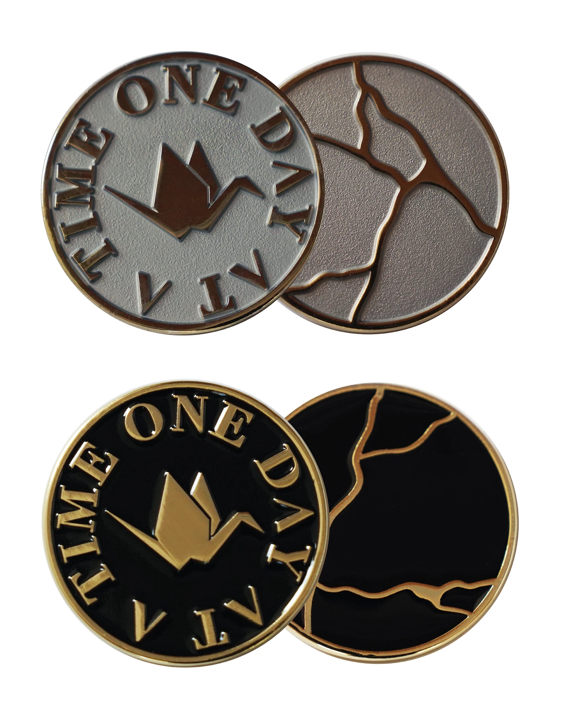 ODAAT Medallions – Kintsugi Edition. Top: silver coin with gold origami crane and “ONE DAY AT A TIME” text, reverse side with gold kintsugi crack design on silver background. Bottom: black coin with gold origami crane and text, reverse side with gold kintsugi crack design on black enamel.