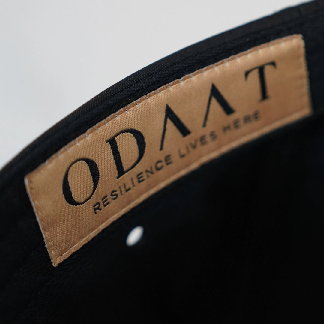 Close-up of the Progress Over Perfection Hat’s interior label reading ‘ODAAT – Resilience Lives Here,’ stitched inside as a subtle daily reminder.