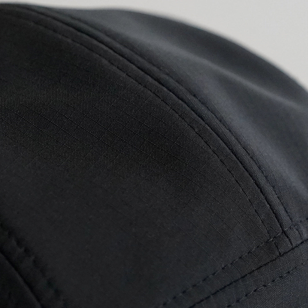 Close-up of the Progress Over Perfection Hat’s ripstop nylon crown and double-stitched seams—engineered with increased diameter for broader fit and all-day comfort.
