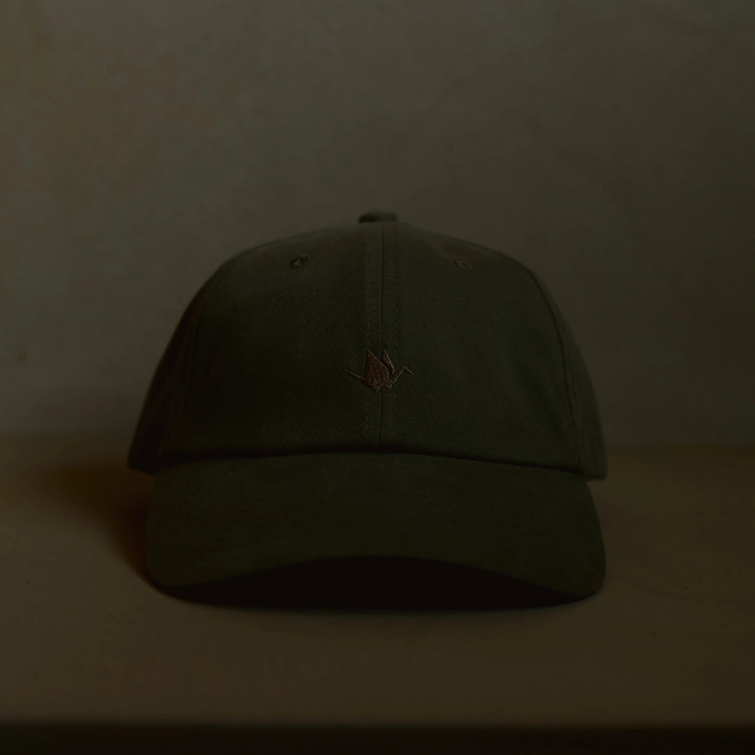 Olive dad cap with crane embroidery, unstructured crown and curved brim, ODAAT Signature Cap front view on neutral background.