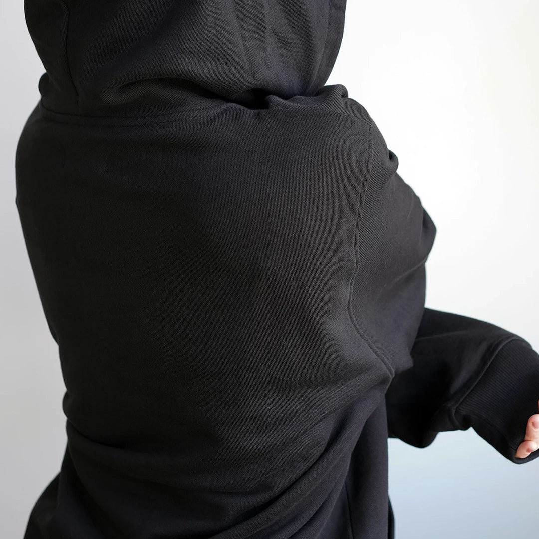 Back view of black sustainable hoodie made from organic cotton — crafted without harmful chemicals and using 50% less water than conventional methods. Minimalist, eco-friendly streetwear by ODAAT Apparel.