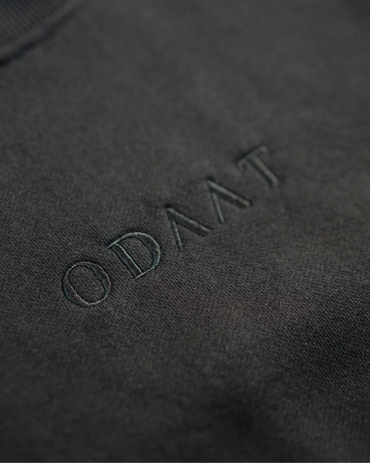 Tonal ODAAT wordmark embroidery on black French terry