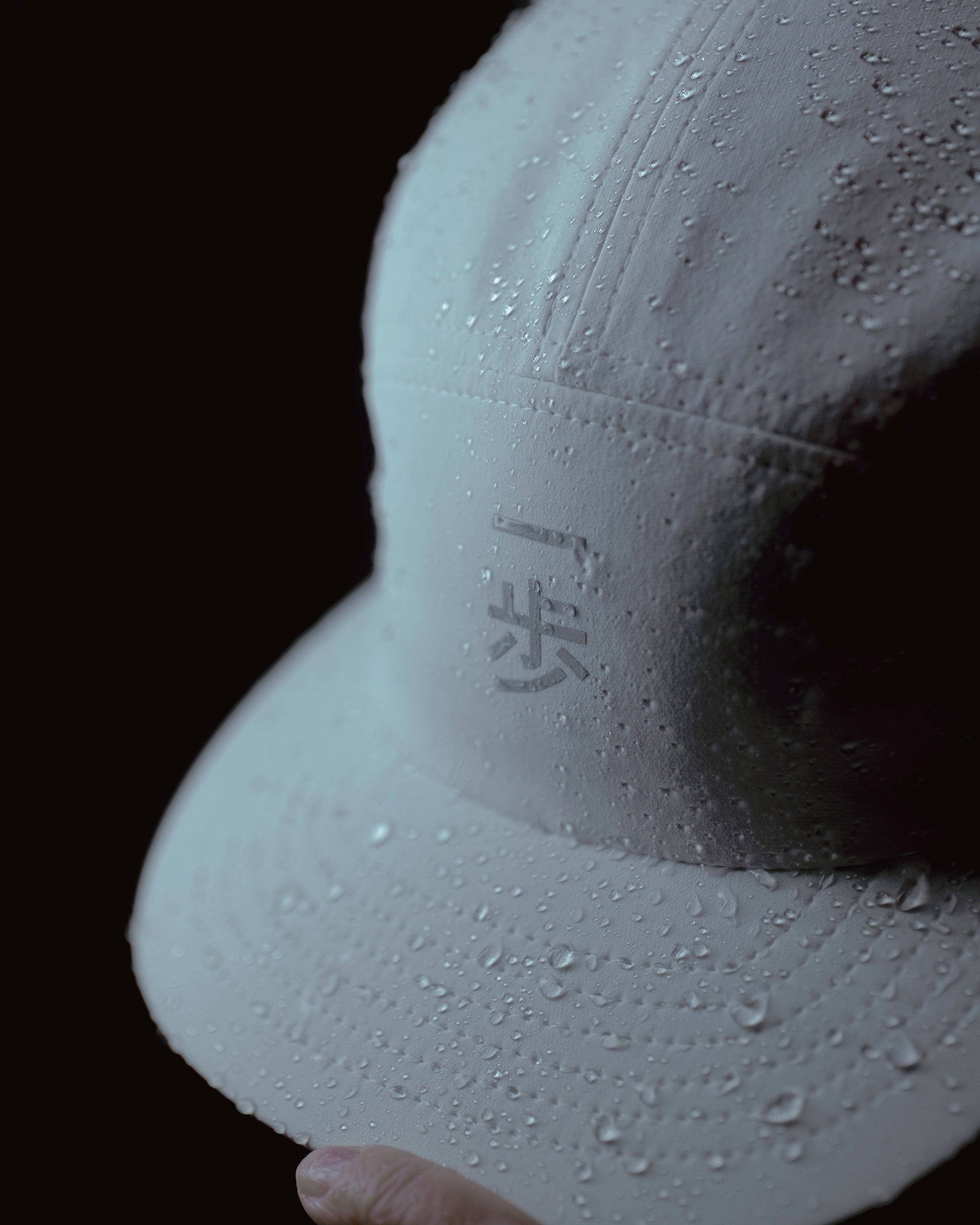 White KyoPace running cap with kanji, close-up detail showing water droplets on fabric