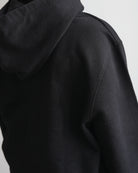 Black hoodie, back view showing the hood and shoulder