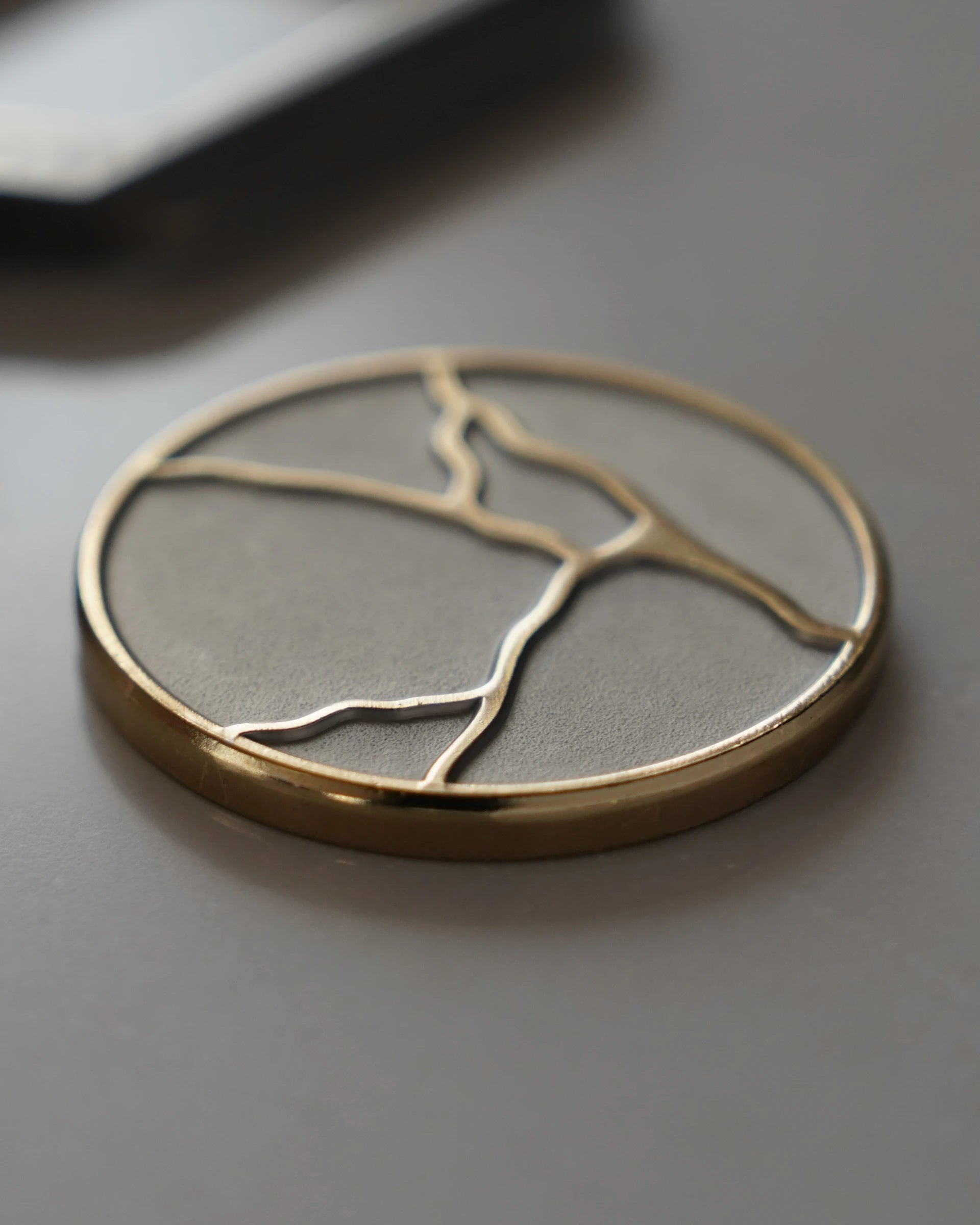 ODAAT Medallion — Kintsugi Edition reverse side, featuring gold-plated kintsugi crack design on a matte silver background.