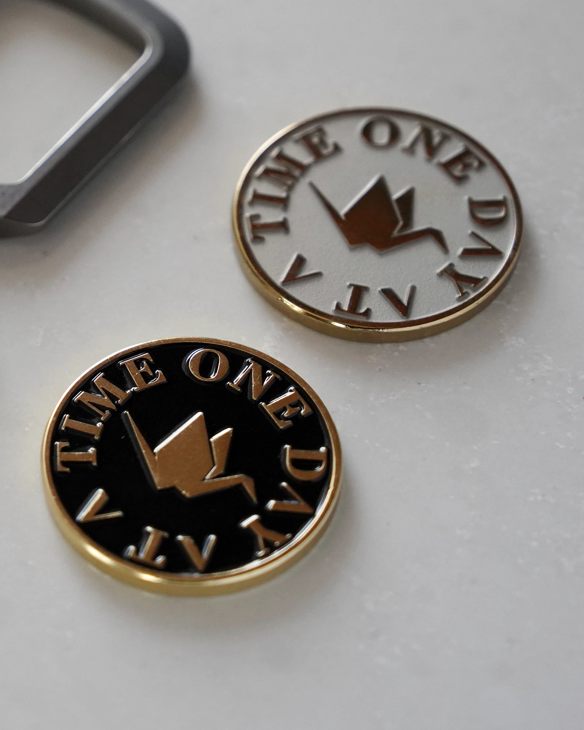 ODAAT Medallion — Kintsugi Edition in Black/Gold and Two-Tone Silver/Gold finishes, featuring crane icon and “One Day At A Time” text.