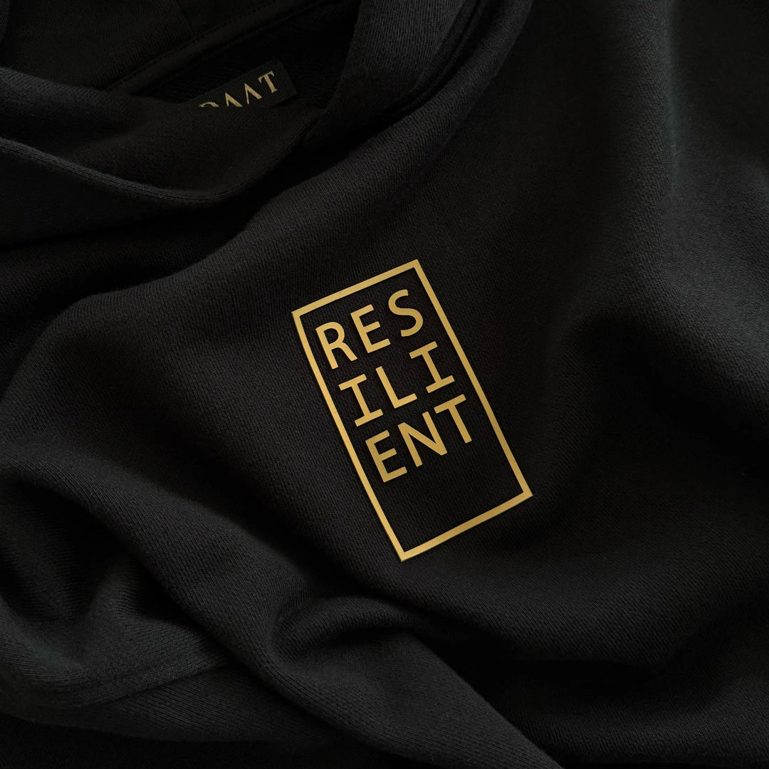 Detail photo of the Resilient Hoodie’s raised tactile print reading ‘RESILIENT’ in a boxed layout—designed for daily, physical affirmation. Made of 100% Organic cotton.