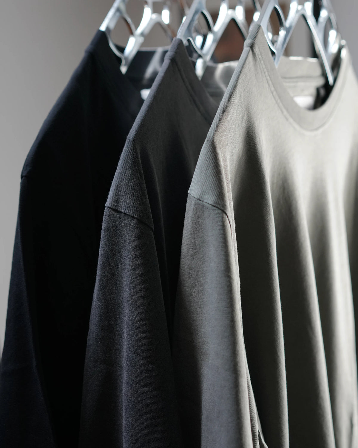 Midweight Tee in Black, Washed Black and Olive on hangers