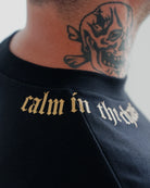 Close-up of Calm in the Chaos boxy cropped tee in black with gold neckline graphic