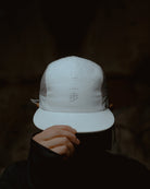 White KyoPace running cap with kanji, front view, worn by model partially covering face